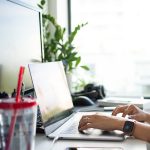 person using macbook pro on table